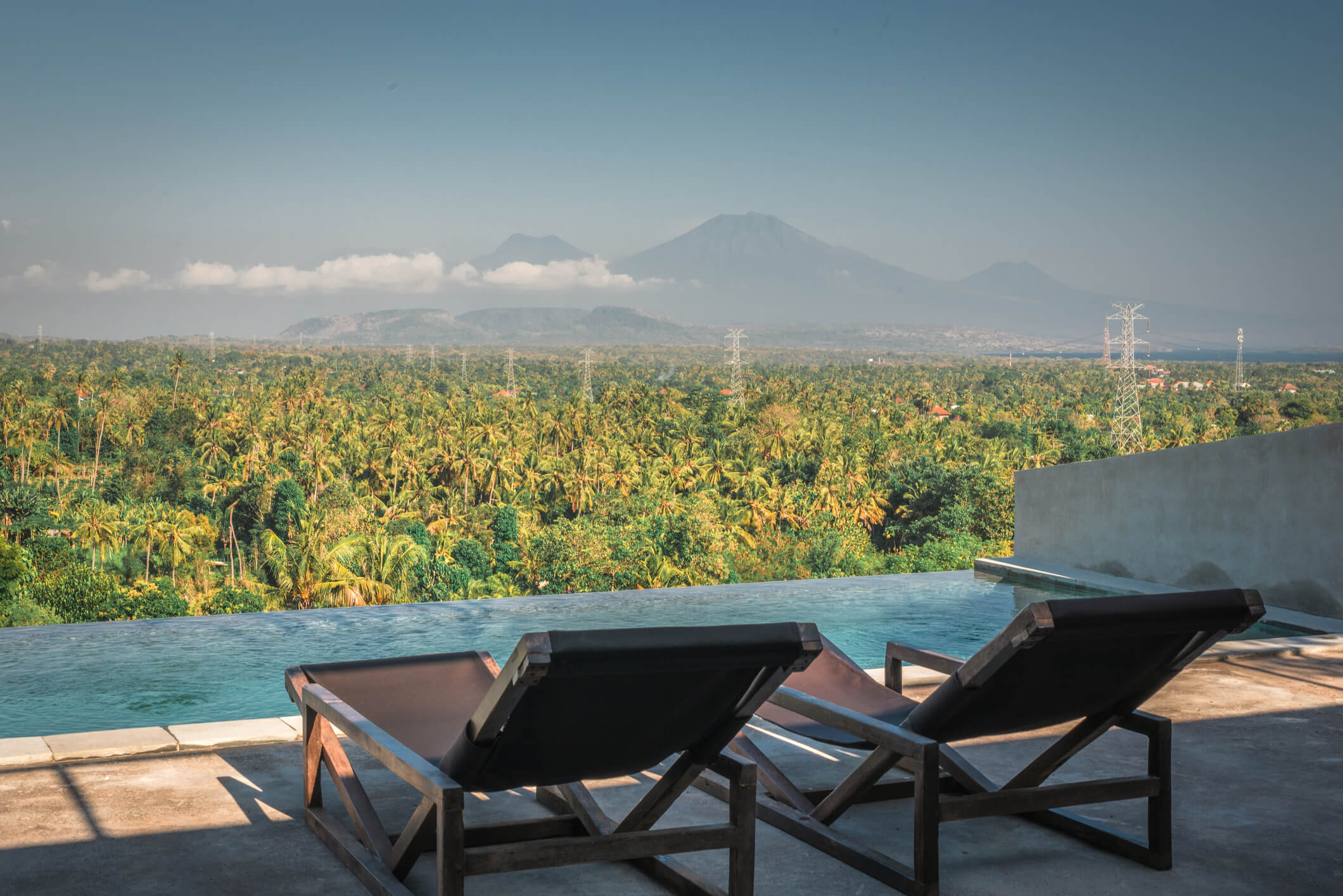 Villa Zaphyr exterior with infinity pool overlooking tropical landscape and distant volcano views
